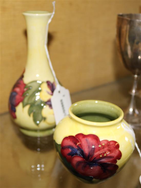 Moorcroft Hibiscus pattern yellow ground bottle vase (post-1953 paper label) and a similar small squat vase